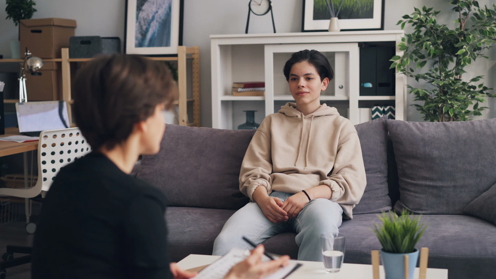 Une adulte échange avec une adolescente dans un salon
