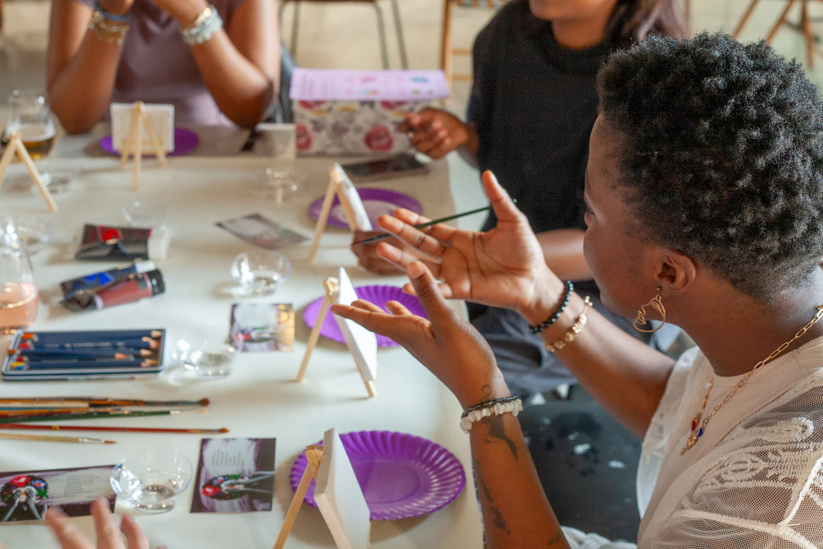 Des adultes créent ensemble autour d’une table de matériel d’arts plastiques