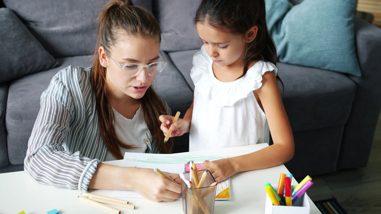 Une maman et sa fille dessinent ensemble à table