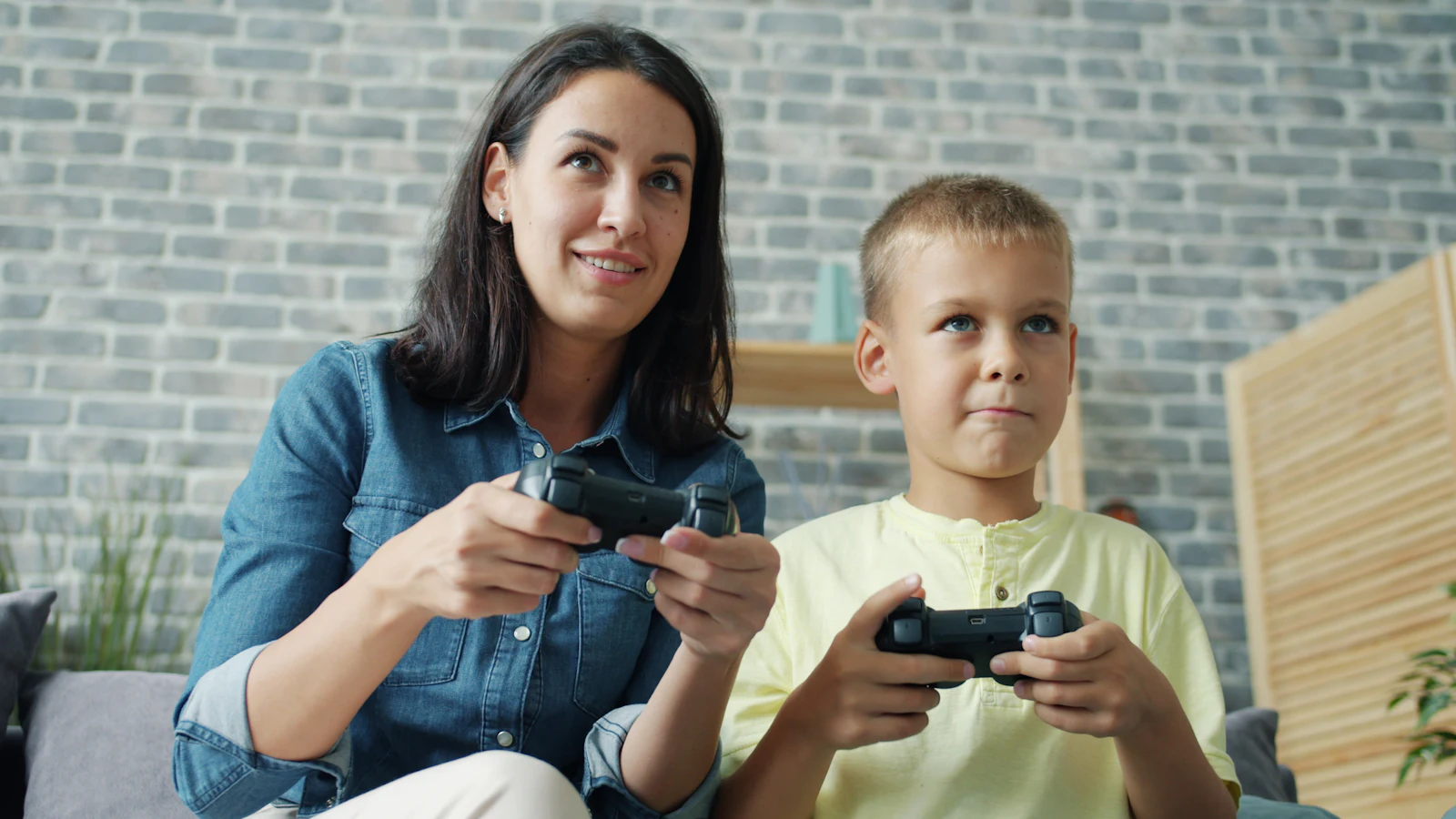 Une maman et son fils jouent ensemble à la console