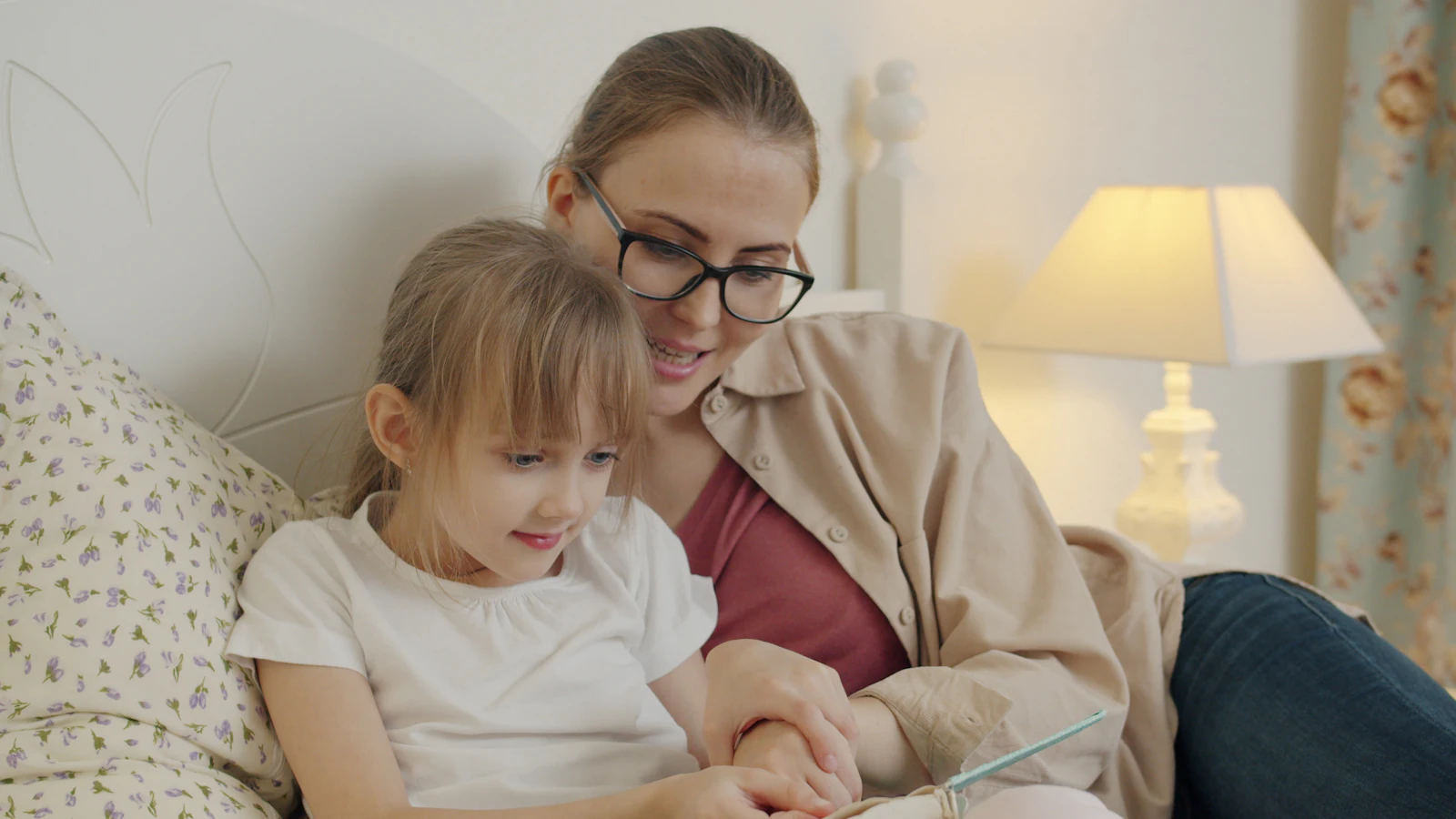 Une maman lit une histoire à sa fille dans une lumière douce